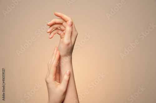 A woman s hands close up  on a beige background.