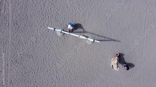 The joy of a family while swinging in gumuk pasir, yogyakarta or the desert area or sand dune. Top view, aerial video drone photo