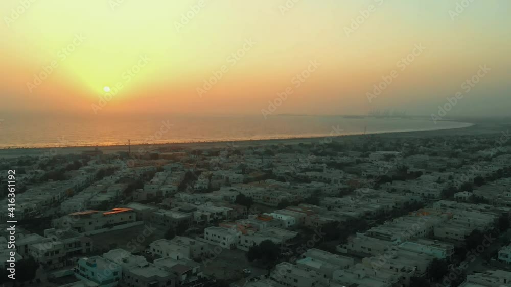 Aerial Sea View Of Golden Sunset Over Residential Housing In Karachi. Slow Pedestal Down Aerial Sea View Of Golden Sunset Over Residential Housing In Karachi. Slow Pedestal Down