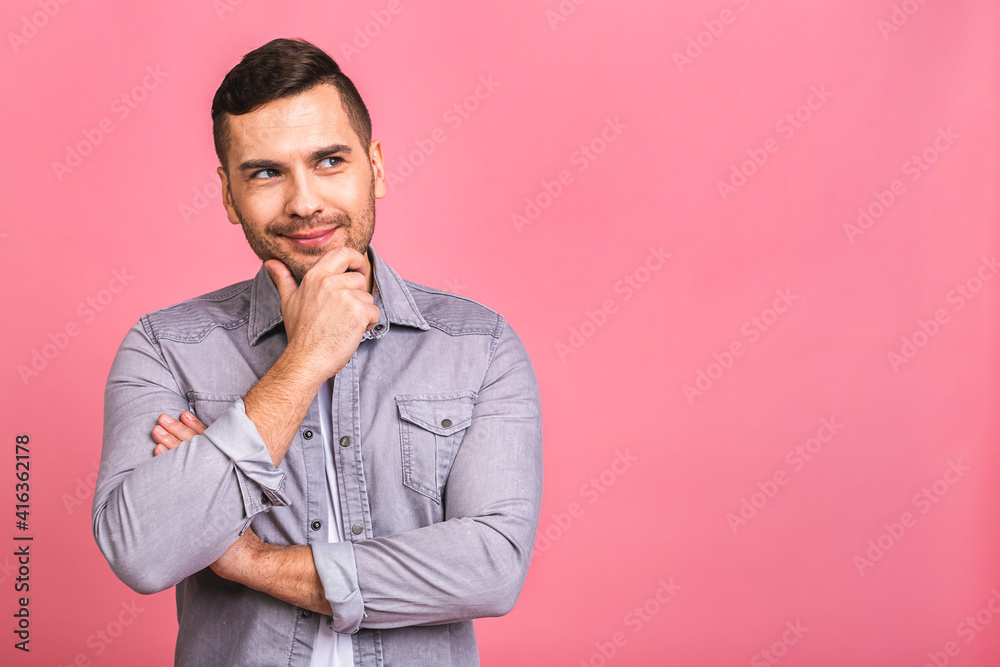 Charming handsome. Handsome cheerful young man in casual wear smiling while standing isolated on pinkbackground. Place for text.