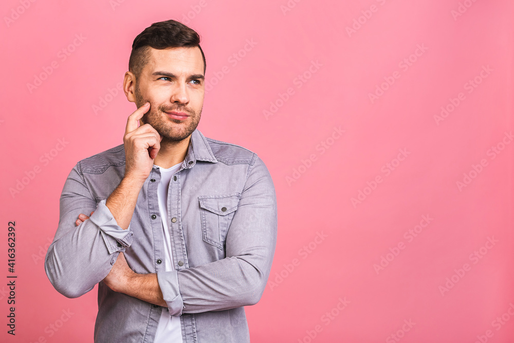 Charming handsome. Handsome cheerful young man in casual wear smiling while standing isolated on pinkbackground. Place for text.