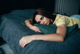 Front view portrait of a beautiful young worried sad woman lying on a sofa