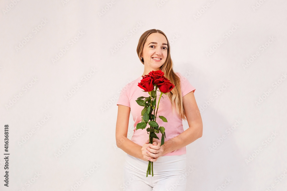 Smiling thirty-year-old woman holds bouquet of red roses Smiling thirty-year-old woman holds bouquet of red roses