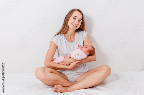Woman holds newborn baby age one week