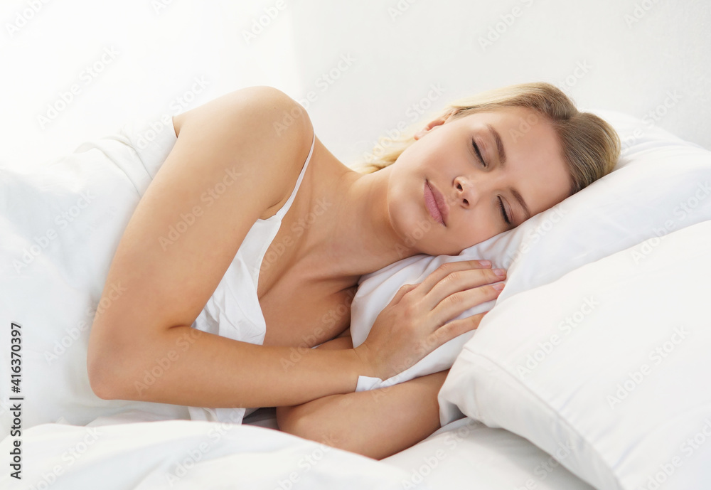 Young and beautiful blond girl in the bed. Sleeping woman in a rays of morning sun. Young and beautiful blond girl in the bed. Sleeping woman in a rays of morning sun.