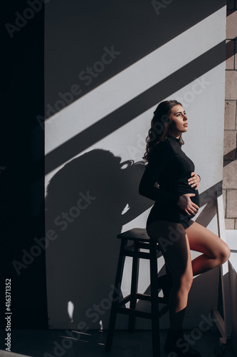 beautiful pregnant woman feeling happy at home while taking care of her child. the young expecting mother holding baby in pregnant belly. healthy. maternity prenatal care and woman pregnancy concept