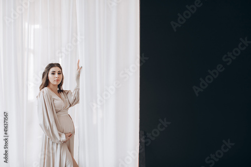 pregnancy, rest, people and expectation concept - happy pregnant woman touching her belly at home