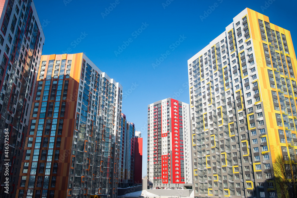 yellow,red and orange high-rise multi-storey house on a background of blue sky