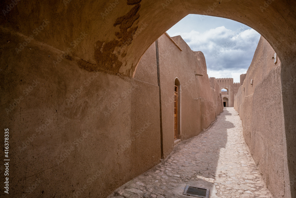 Narrow streets of ancient persian city built from mud bricks. Rayen Citadel, Mahan, Iran.