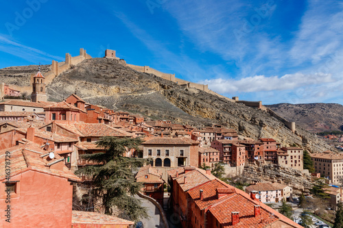 View over Albarricin and its city walls on the hill on a sunny day with a blue sky. Albarracin is located in the province of Teruel, Spain.