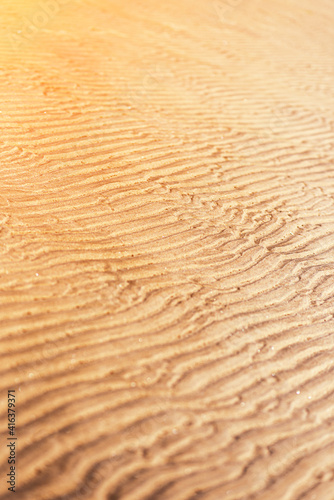 the sea sand on the coast lies in a wavy pattern formed from the water