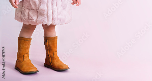 children boots shoes for little fashionistas on a pink background copyspace for text. photo
