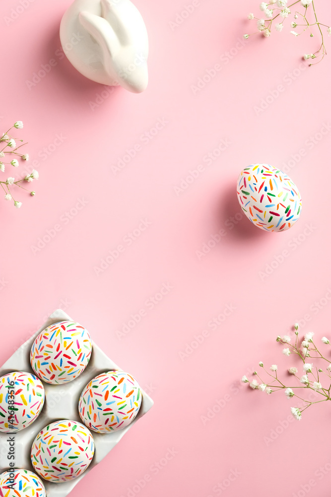 Happy Easter minimal concept. Flat lay, top view Easter eggs, bunny, flowers on pink background.