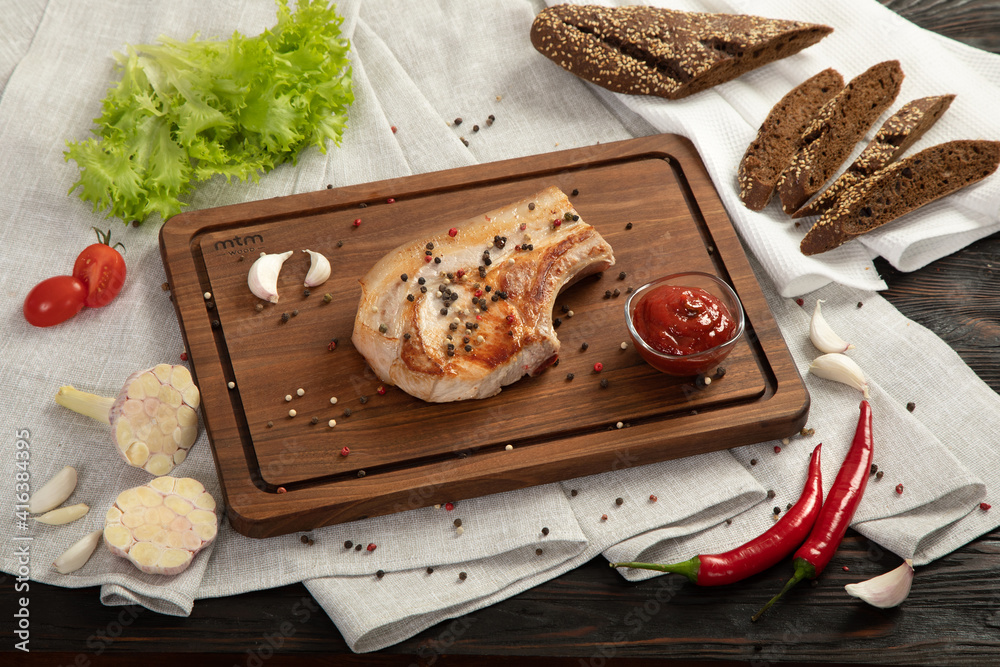 Fried pork entrecote on a board for serving.