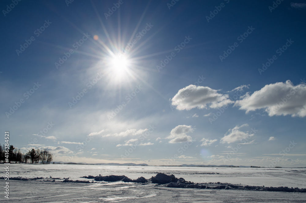 Schneelandschaft mit Sonne und Wolken in Arjeplog, Schweden