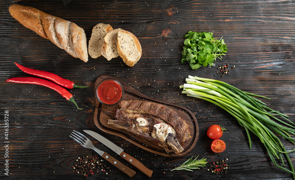 Roasted beef on the bone on a board for serving.