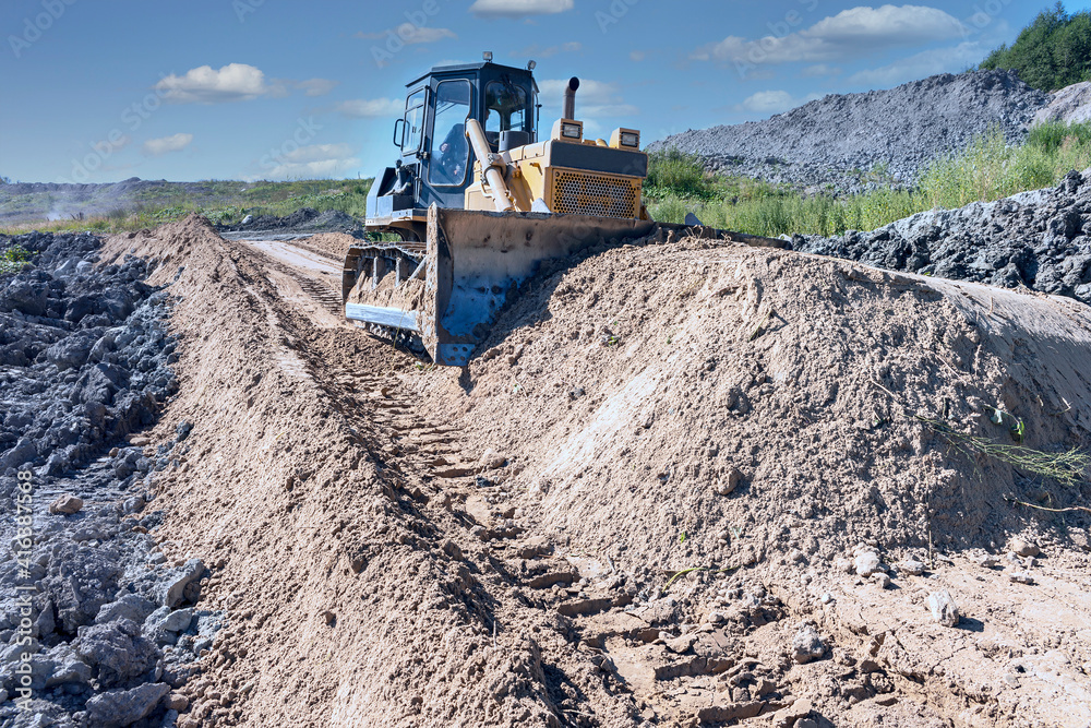 the process of leveling sand with a modern bulldozer during the construction of a dirt road the process of leveling sand with a modern bulldozer during the construction of a dirt road