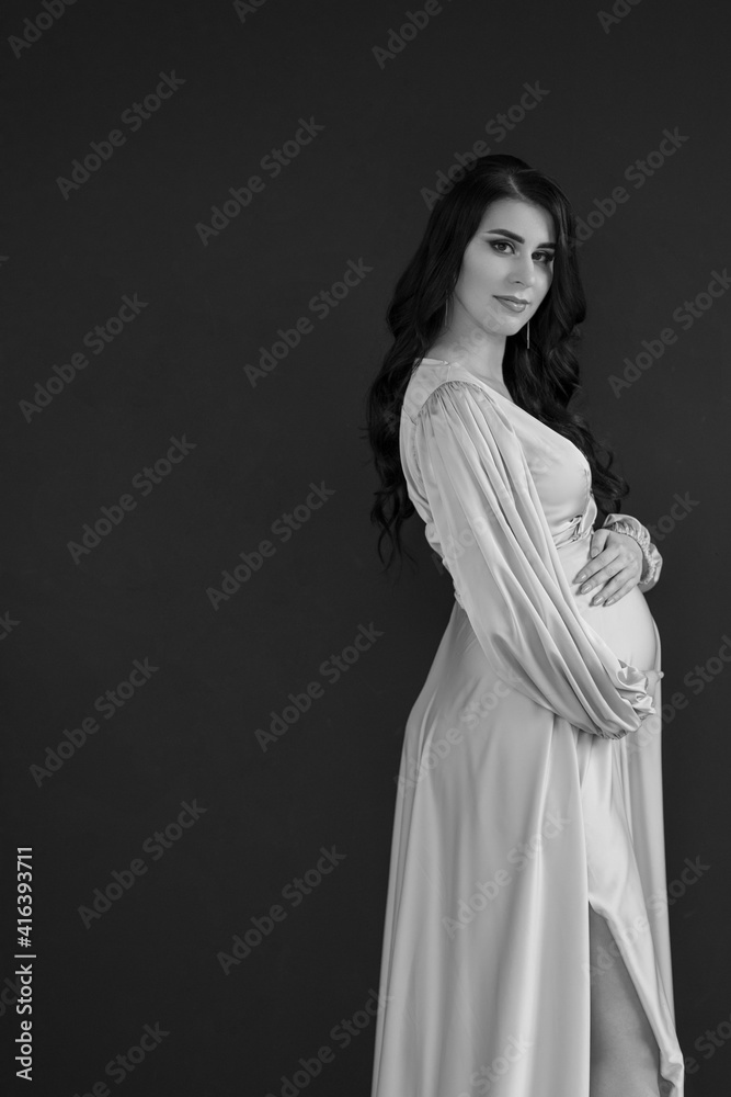 Pregnant Woman touching her belly. Happy Pregnant middle aged mother at home. Female holding her tummy. Healthy Pregnancy concept, Parenthood
