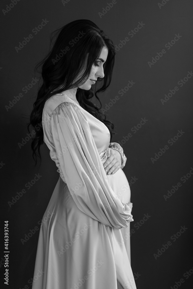 Pregnant Woman touching her belly. Happy Pregnant middle aged mother at home. Female holding her tummy. Healthy Pregnancy concept, Parenthood
