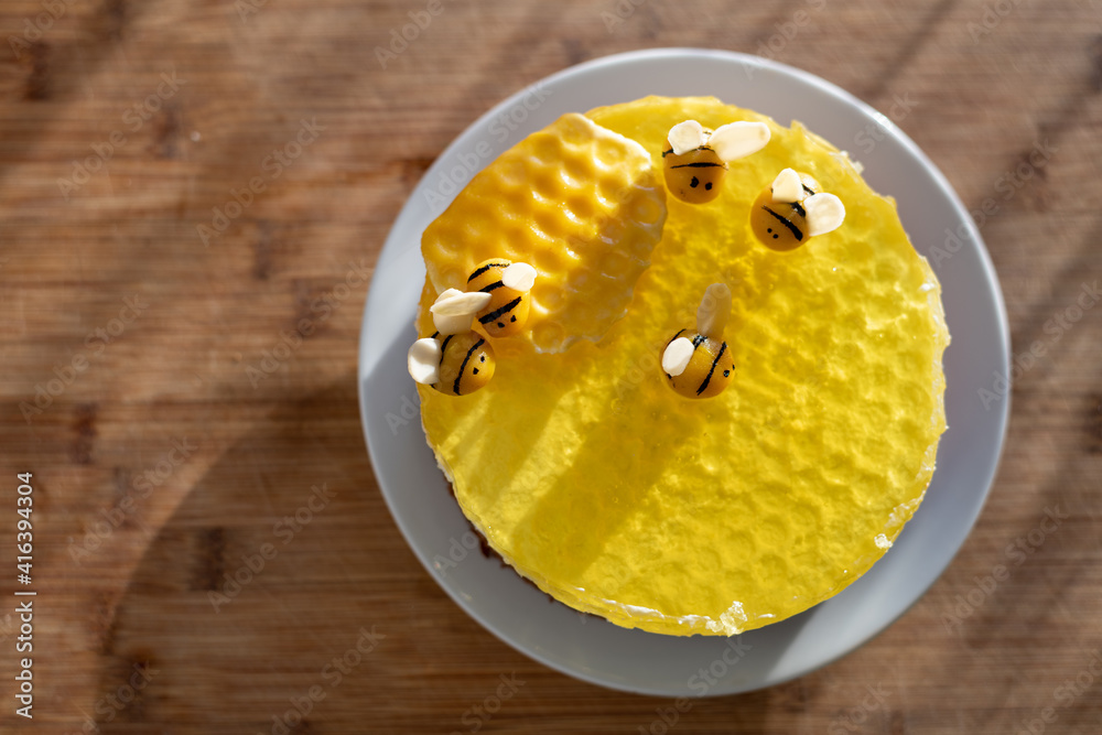 Ein leckerer Kuchen. Torte passend zum Frühling mit Bienenfiguren und gelber Gelatine auf einem weißen Teller. Ein leckerer Kuchen. Torte passend zum Frühling mit Bienenfiguren und gelber Gelatine auf einem weißen Teller.