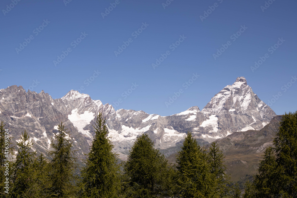 High mountains covered with snow and in the foreground a green forest. Beautiful landscape. High mountains covered with snow and in the foreground a green forest. Beautiful landscape.