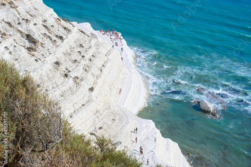 Tourists stroll and sunbathe at the 