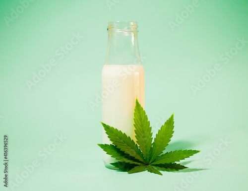 Hemp milk in the bottle. Cannabis leaf. CBD infused. Healthy plant based vegan beverage.  photo