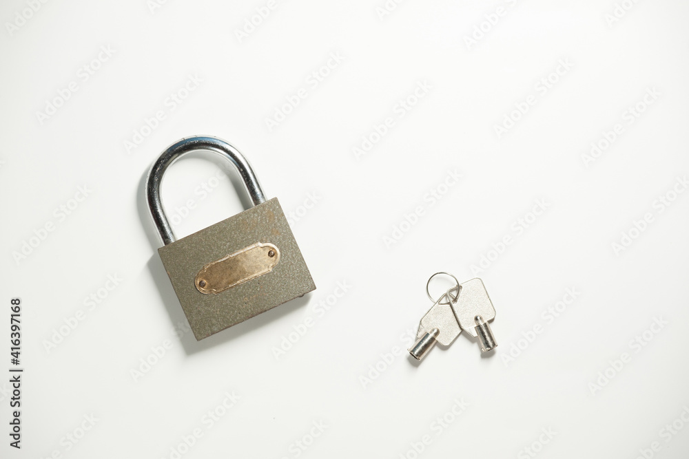A gray metal padlock with a pair of keys on the white background. Top view A gray metal padlock with a pair of keys on the white background. Top view