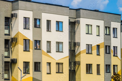 Facade typical middle storey residential building under a blue cloudy sky and footpath slope