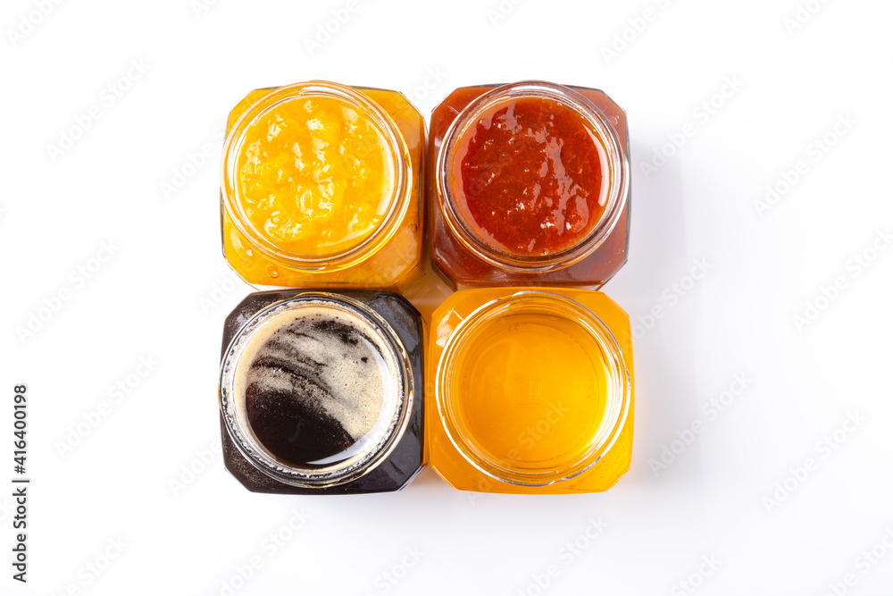 jars of peach and apricot jam and light and dark honey on a white background top view jars of peach and apricot jam and light and dark honey on a white background top view
