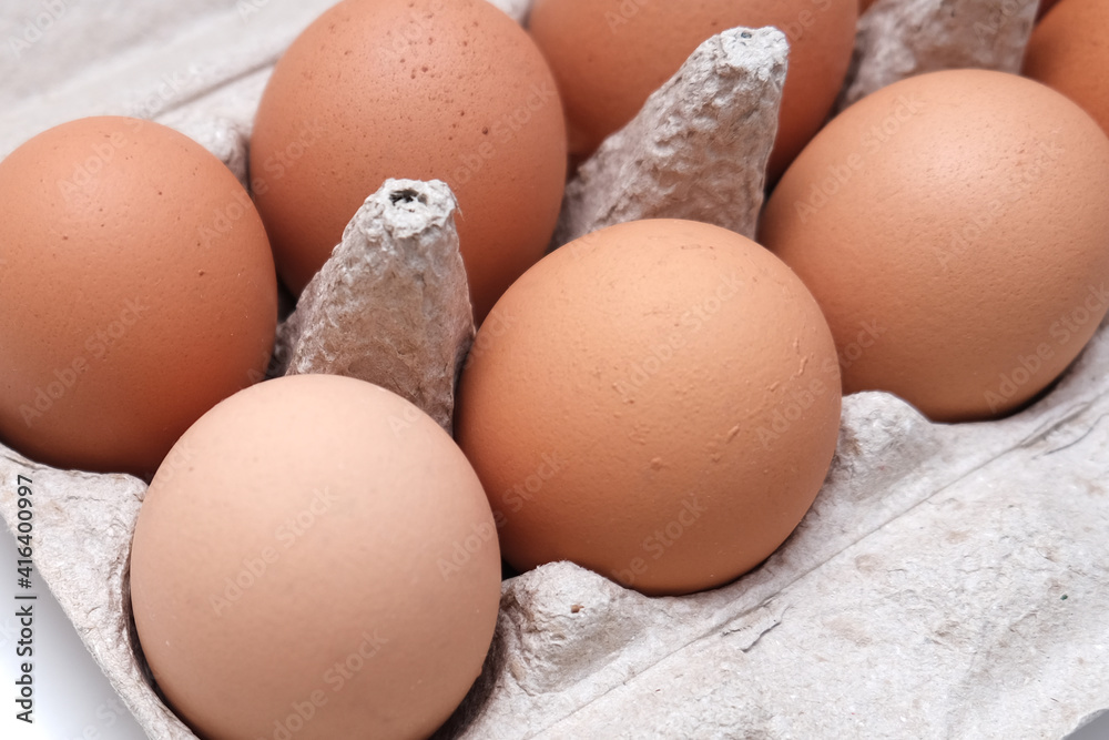 Brown eggs in recycled carton pressed box container close up Brown eggs in recycled carton pressed box container close up
