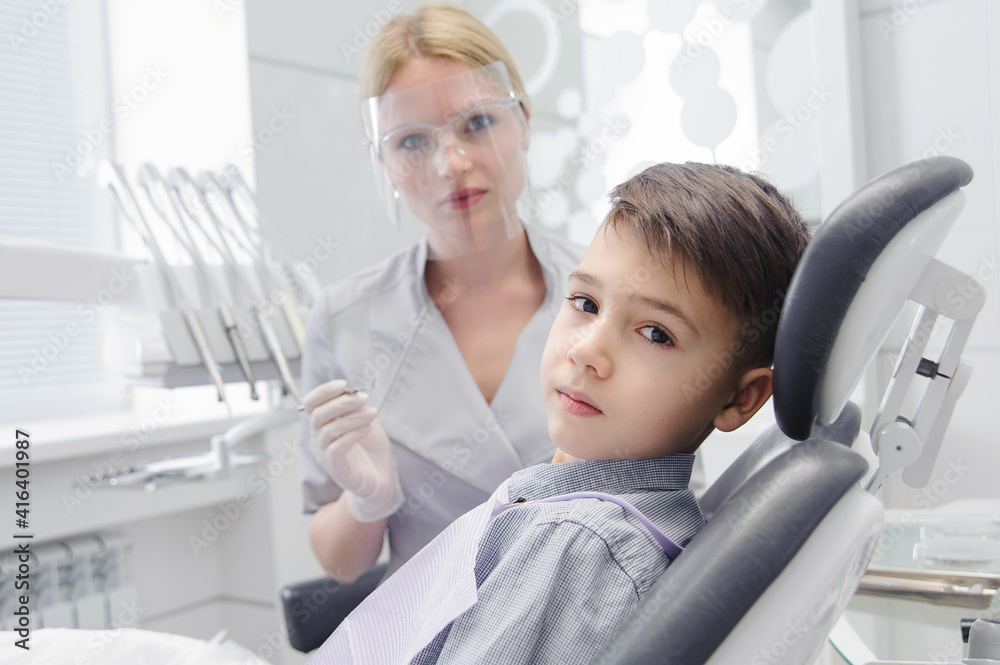 Obraz premium A child boy with a dentist in a dental office