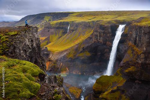 Hiker standing at the edge of the Haifoss waterfall in Iceland