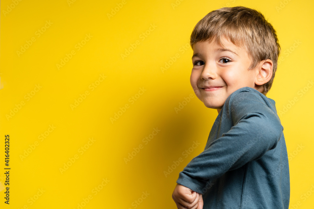 Portrait of happy joyful small caucasian boy in front of yellow background making faces - Childhood growing up and achievement concept - front view waist up copy space Portrait of happy joyful small caucasian boy in front of yellow background making faces - Childhood growing up and achievement concept - front view waist up copy space