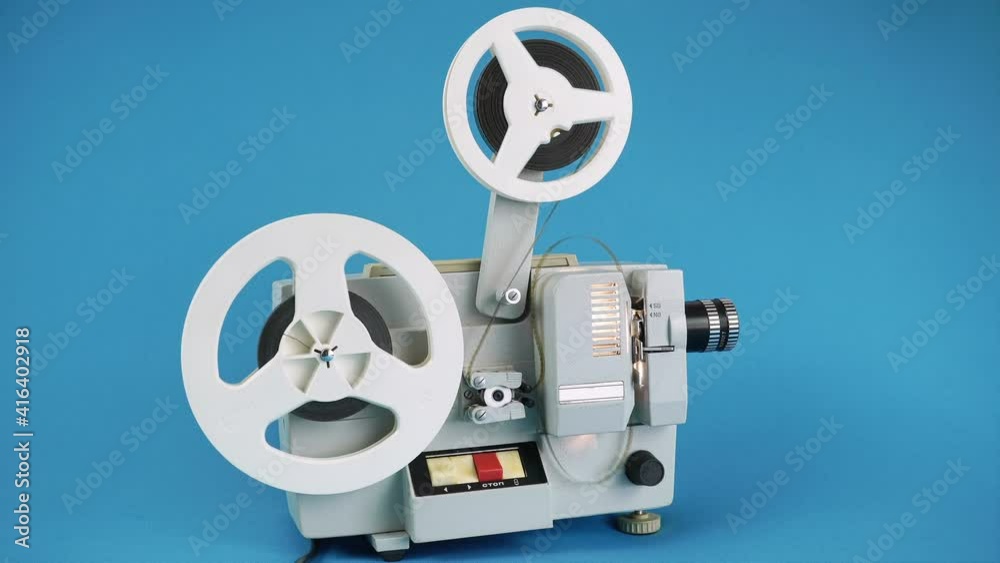 Retro Movie Projector Work On A Blue Background.
Retro Movie Projector Work On A Blue Background.