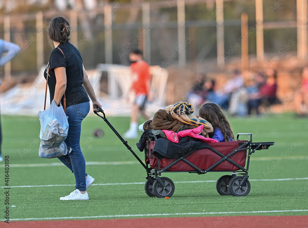 Obraz premium Little girl being pulled in a wagon at a sporting event