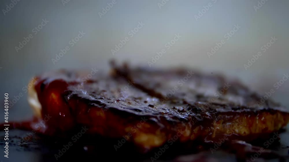 Frying steak covered with red sauce on a griddle Frying steak covered with red sauce on a griddle