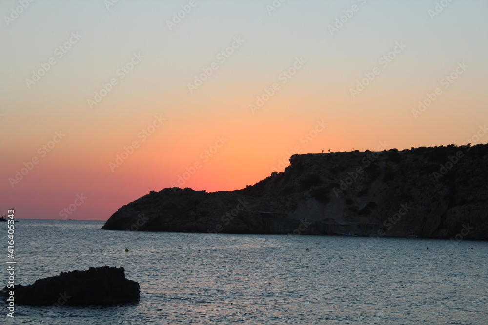 Sonnenrot am Felsen auf Ibiza mit dem Meer