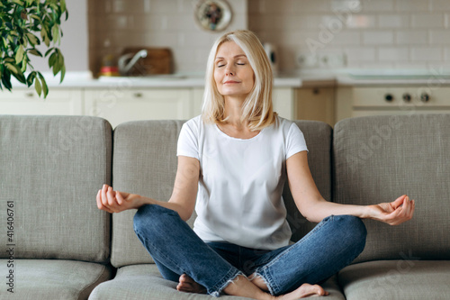 Photography Calm attractive middle aged woman sits on sofa at home and chilling