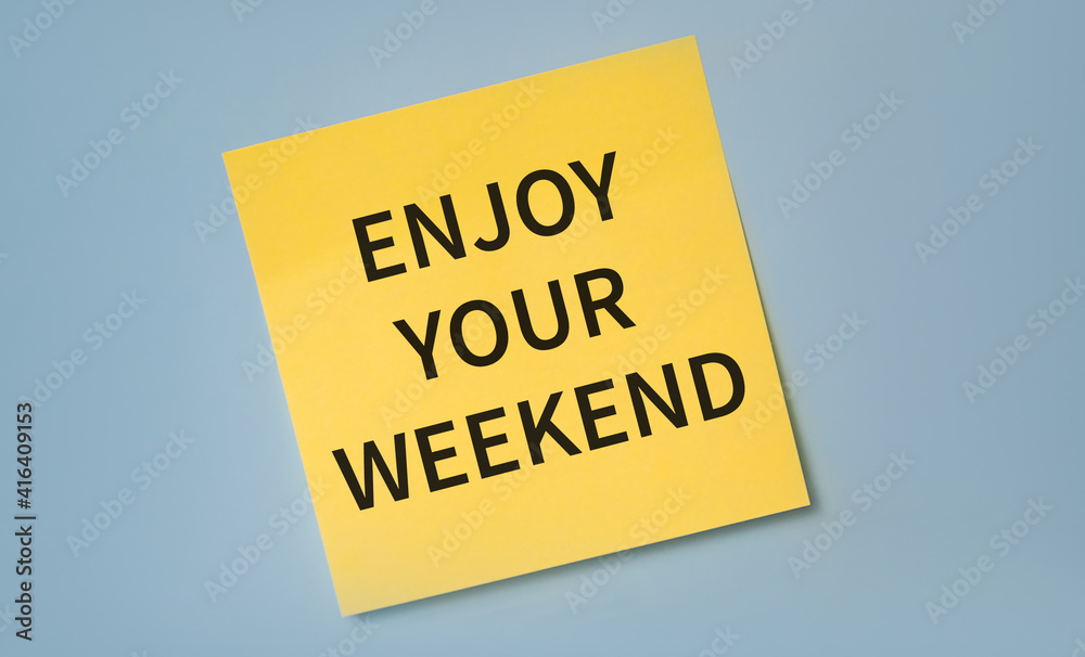 Enjoy The Weekend written on yellow stocker against blue background. Enjoy The Weekend written on yellow stocker against blue background.