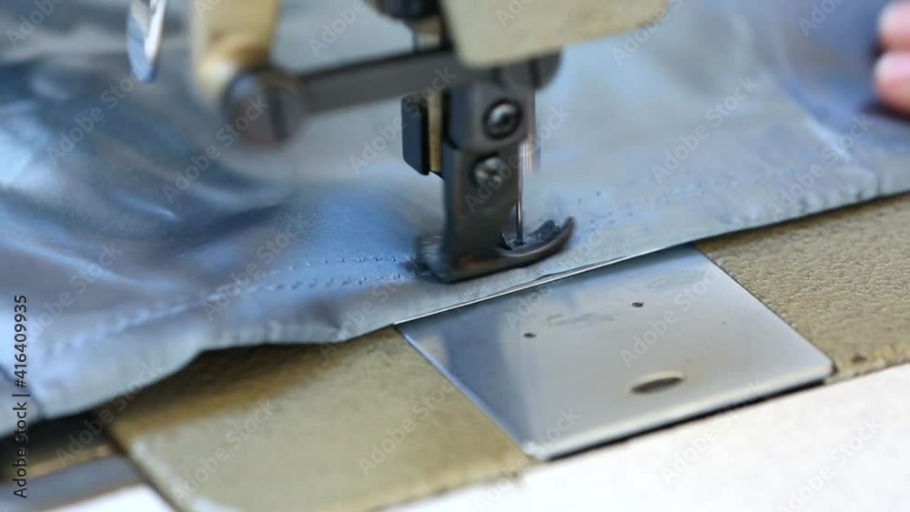 A sewing machine close up where the needle sewing a fabric shelf A sewing machine close up where the needle sewing a fabric shelf
