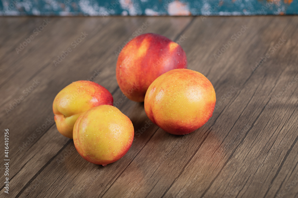 Red and yellow peaches on a wooden table Red and yellow peaches on a wooden table