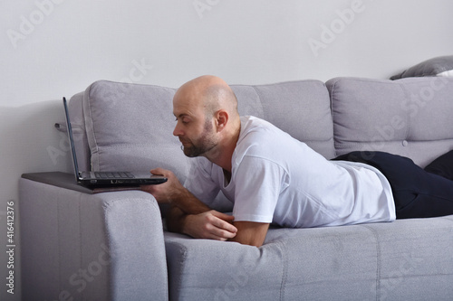 Young man in livingroom using laptop © yevgeniya131988