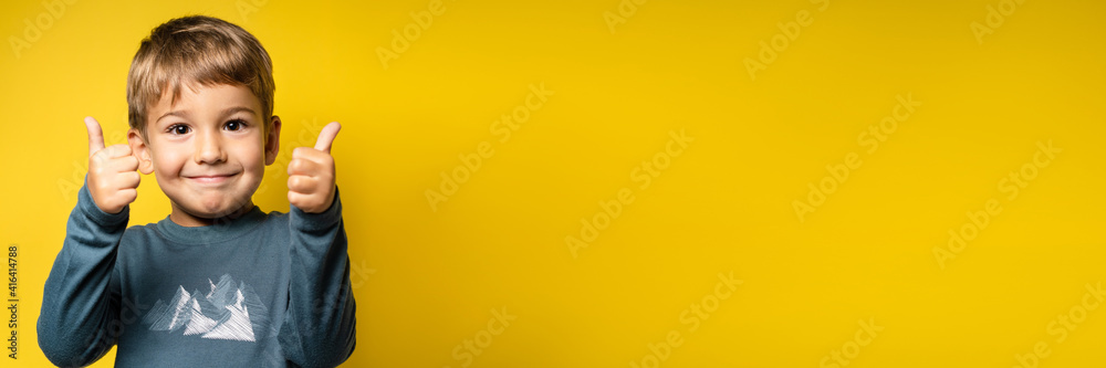 Portrait of happy small caucasian boy in front of yellow background thumbs up - Childhood growing up and achievement concept - front view waist up copy space Portrait of happy small caucasian boy in front of yellow background thumbs up - Childhood growing up and achievement concept - front view waist up copy space