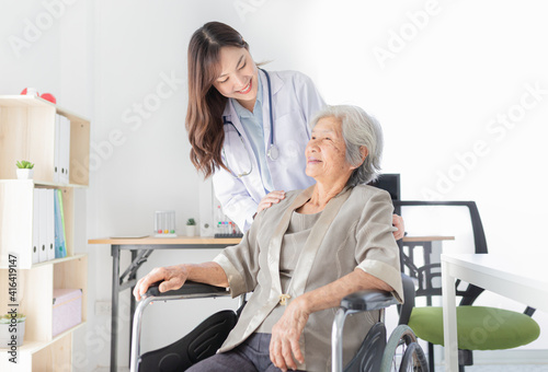 close up patient, Asian doctor drive wheelchair and touch on shoulder of patient, doctor and old female talk about symptoms and treatment plan, rehabilitation activity, elderly healthcare promotion