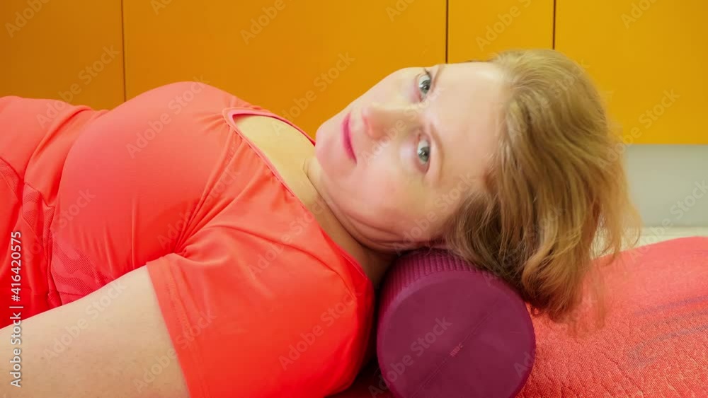 Blonde adult woman does exercises to improve spibe health and to reduce pain. Taking care of body. Blonde adult woman does exercises to improve spibe health and to reduce pain. Taking care of body.