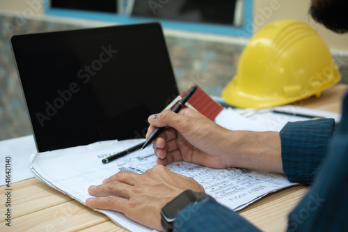 Worker working in office with laptop computer and work house design for building
