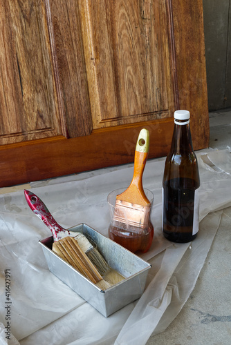 Paint Brush in the Plastic Jar contained Lacquer Prepared for Wooden Door Lacquering.