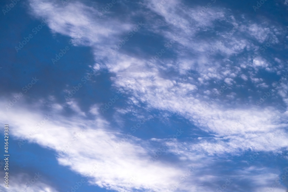 This image shows an idyllic scene where a white cloudscape fills a blue sky.