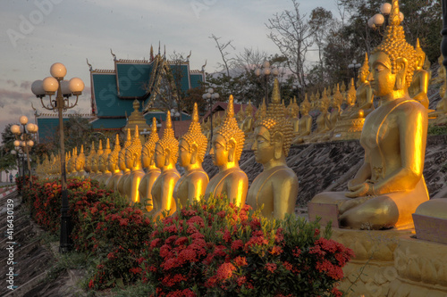Golden Buddha statues at sunset in Pakse Laos